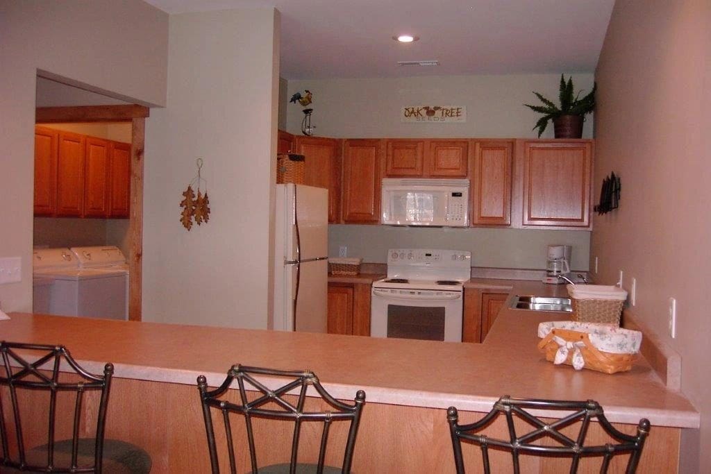 A kitchen with wooden cabinets and white appliances.