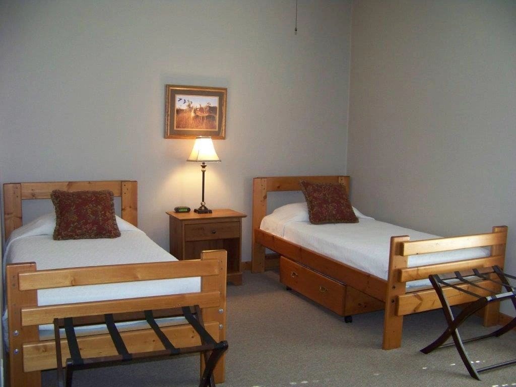 A bedroom with two beds and a lamp